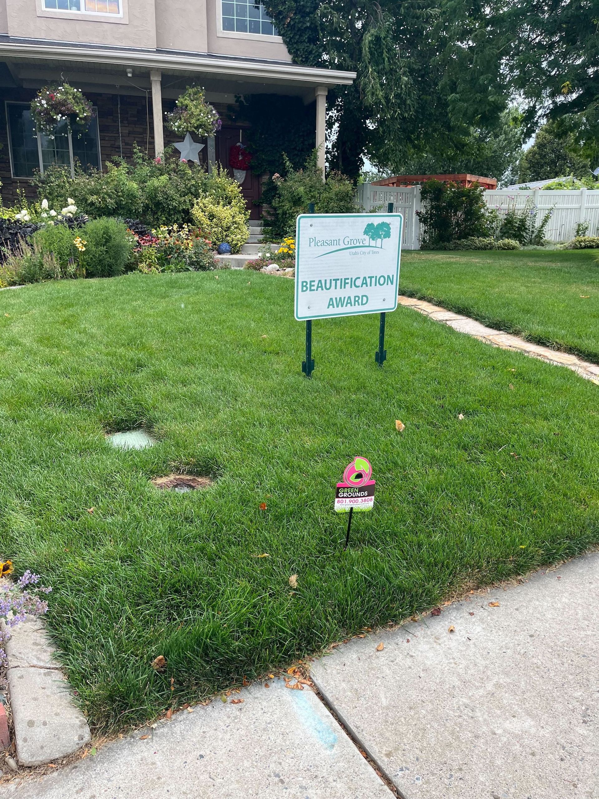 A sign in the grass in front of a house.