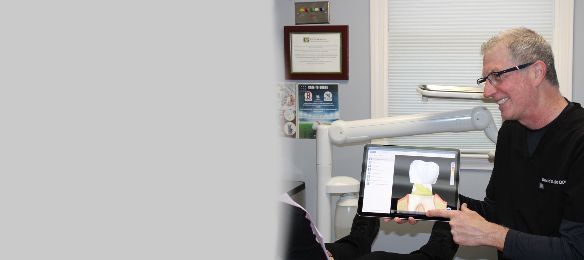 Dentist pointing at a digital tooth image on a tablet, in a dental office.