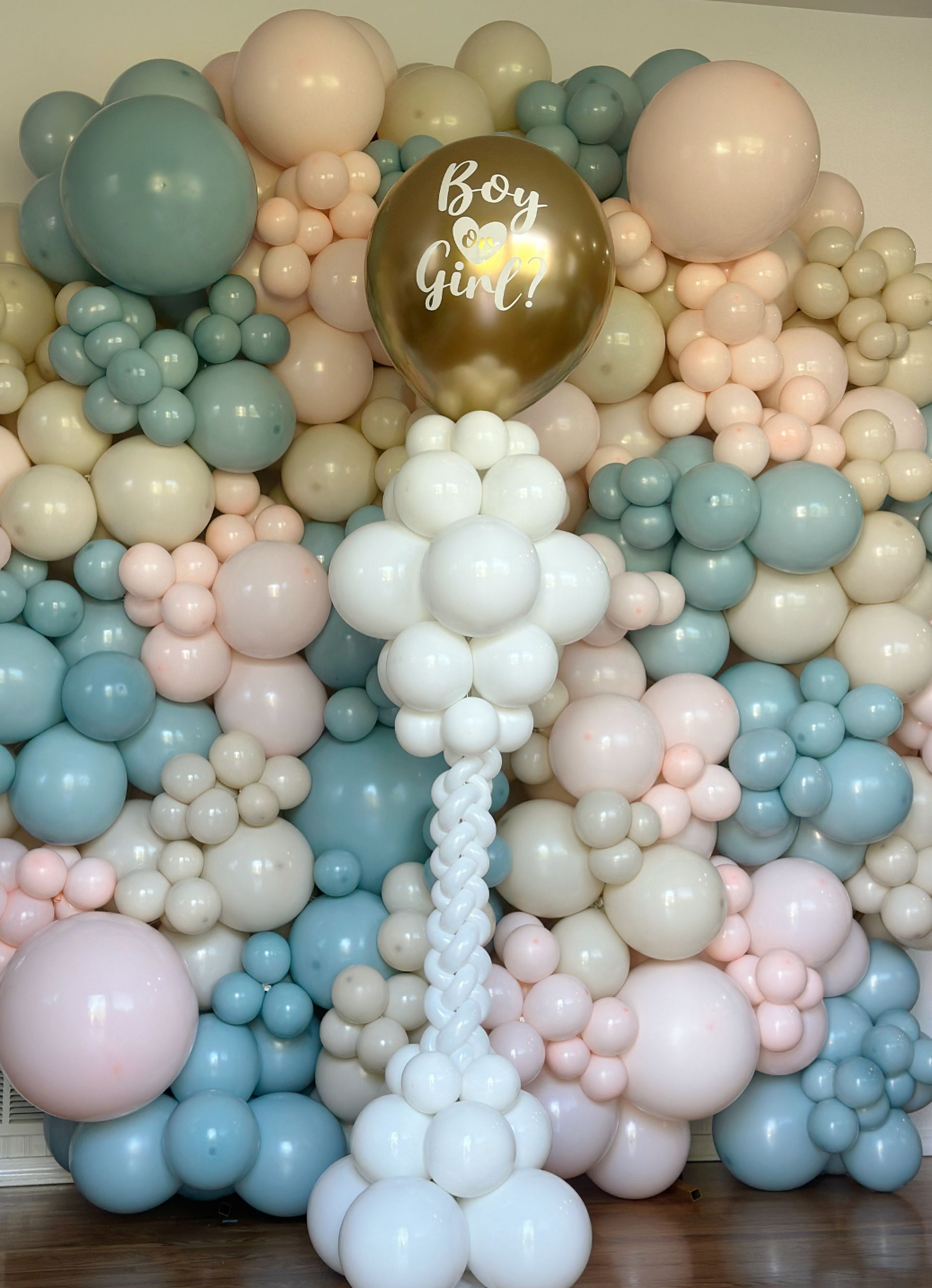 Balloon wall with pink, blue, cream, and gold balloons. A gold balloon reads