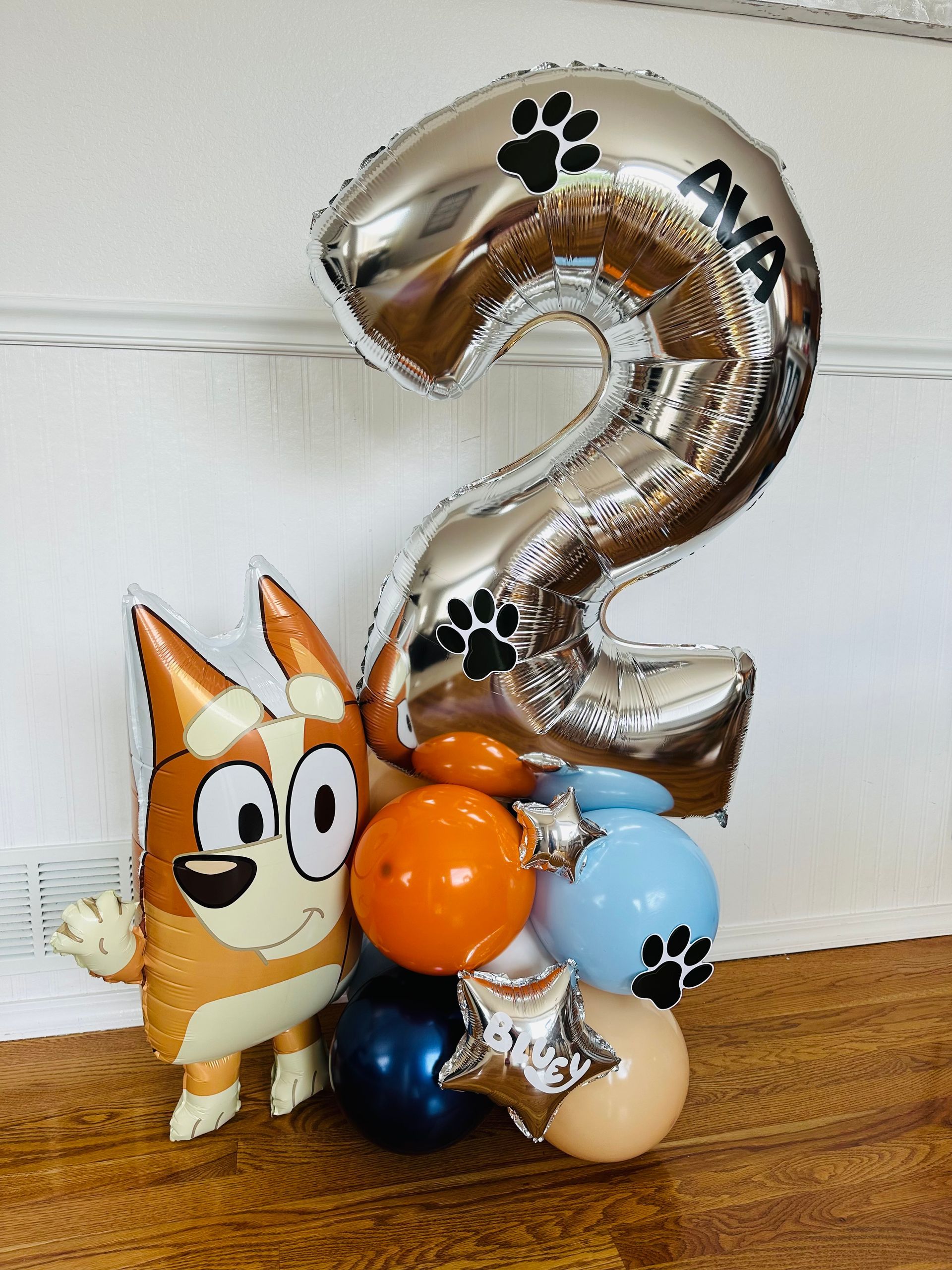 Balloon bouquet with a blue Heeler cartoon, a silver number