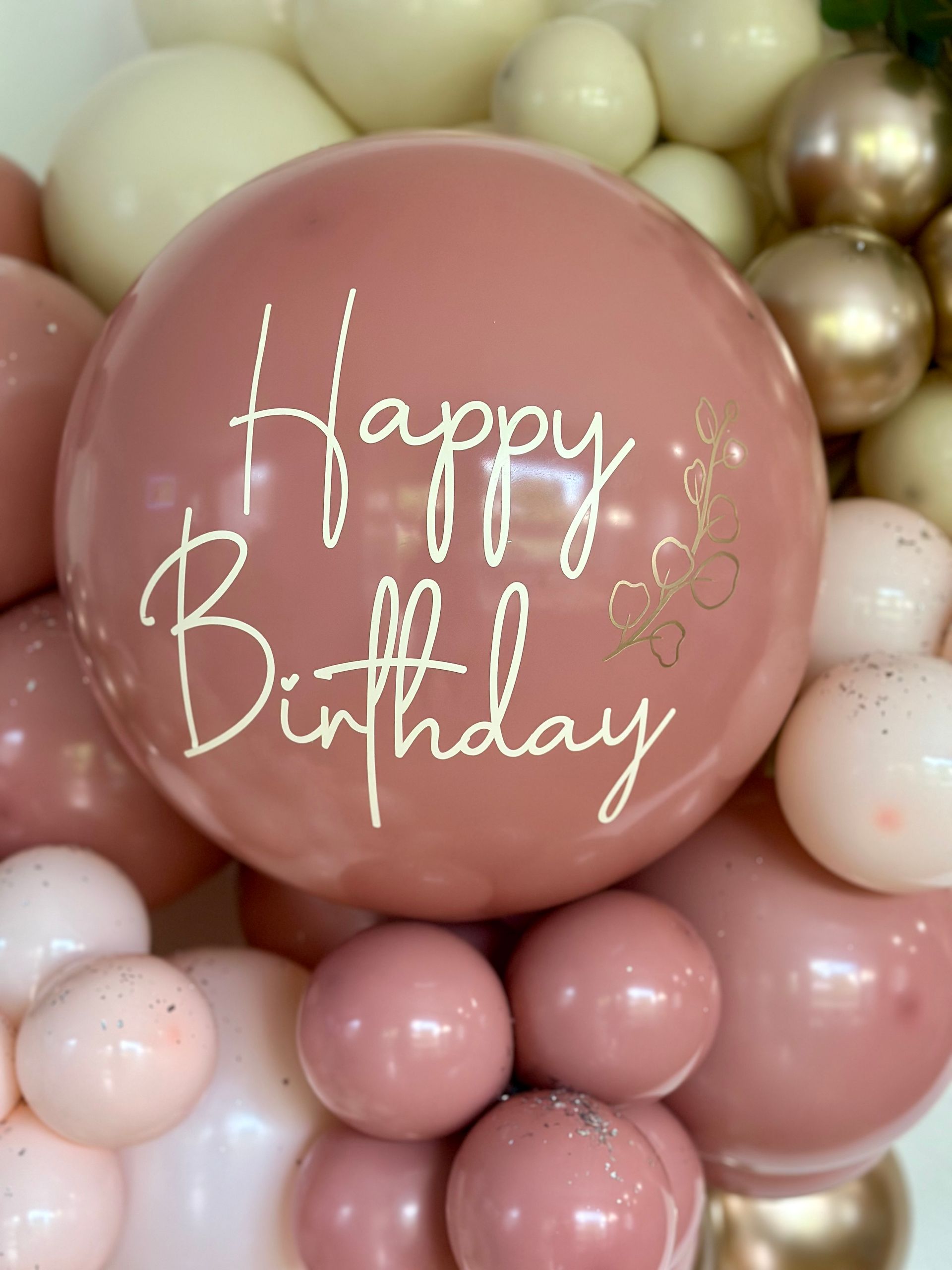 Pink and cream balloon arch with a large