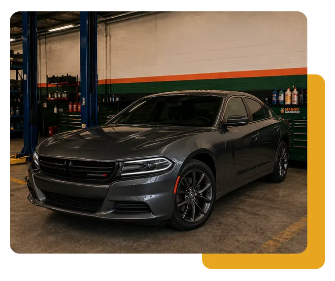 Dark gray sports sedan parked in a garage, shown at an angle.