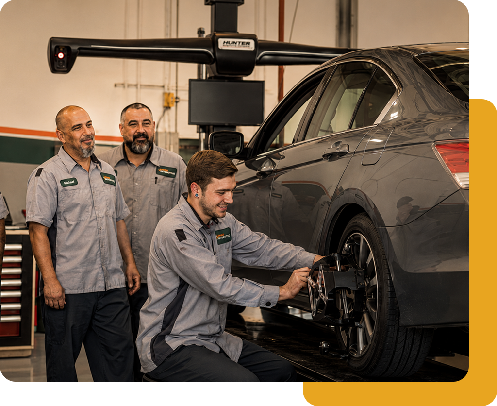 Mango Automotive technicians checking a sedan on a wheel alignment rack