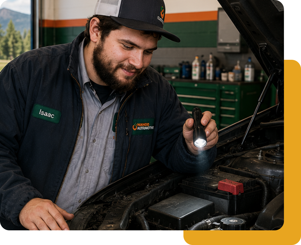 Mechanic inspecting engine bay with a flashlight beside an open hood