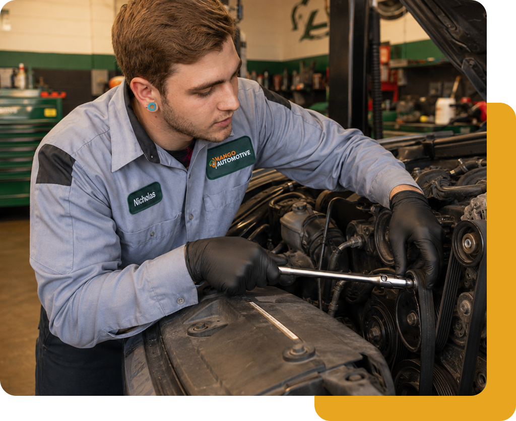 Mango Automotive technician working on an engine with a socket wrench