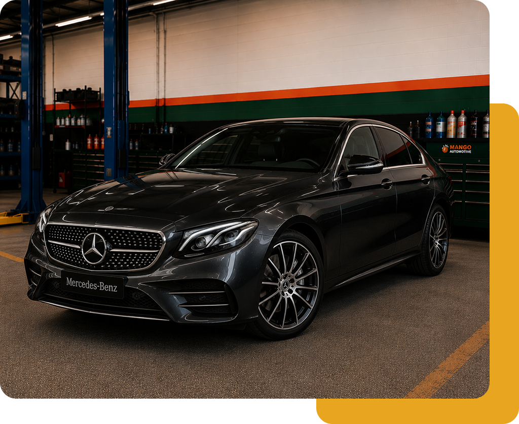 Black Mercedes sedan parked indoors under garage lighting