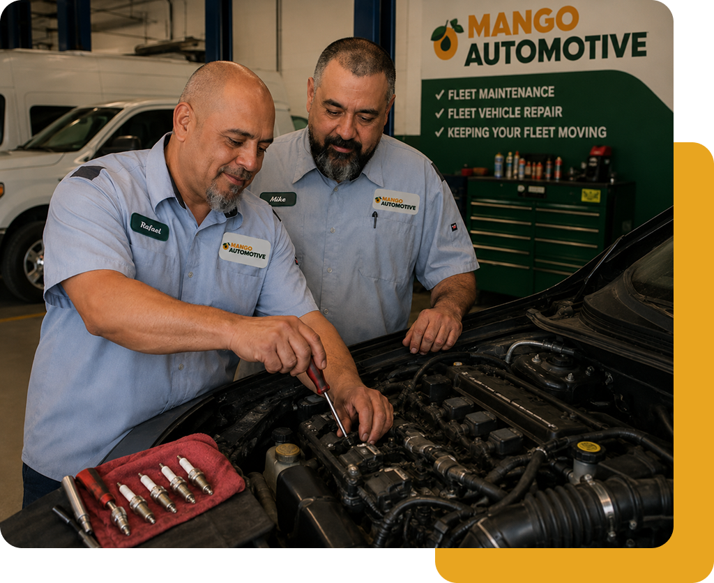 Two mechanics inspecting a car engine in a Mango Automotive workshop with tools nearby