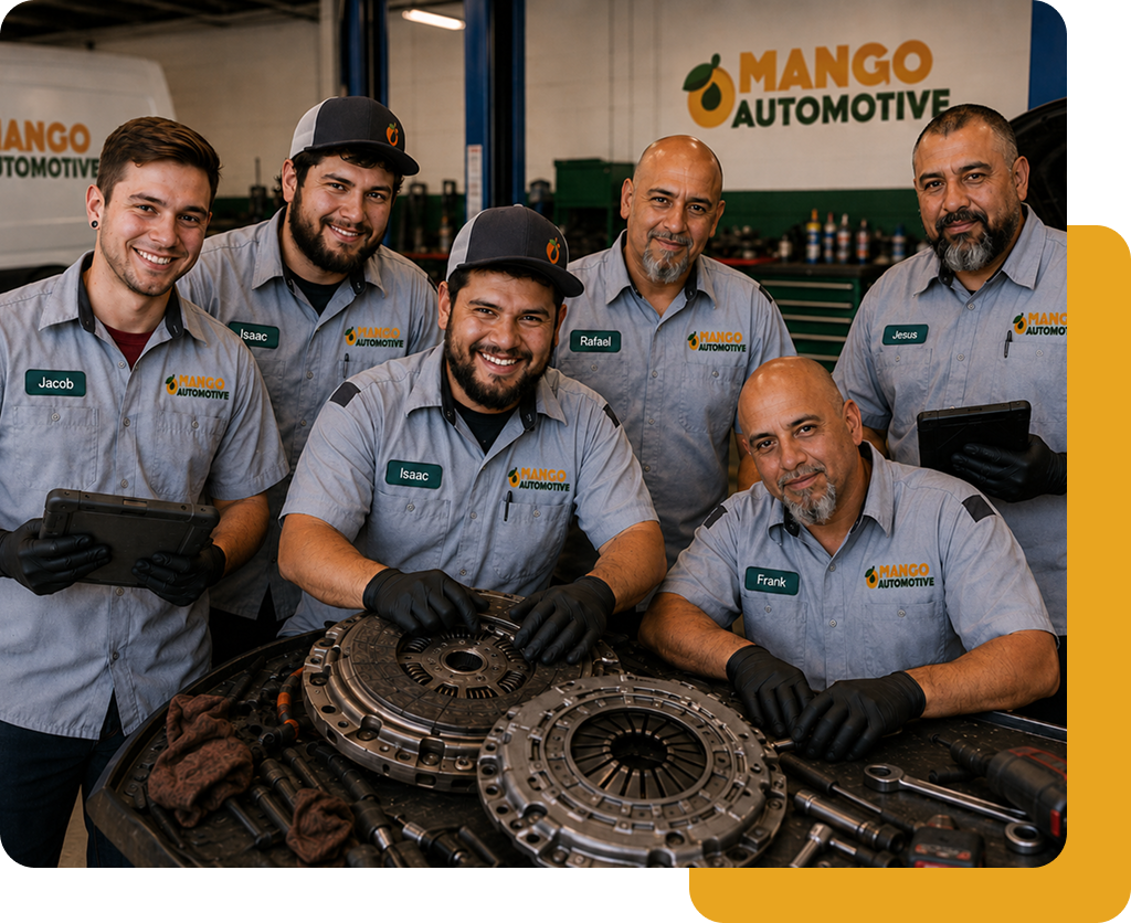 Six auto technicians in gray uniforms posing with automotive parts at Mango Automotive