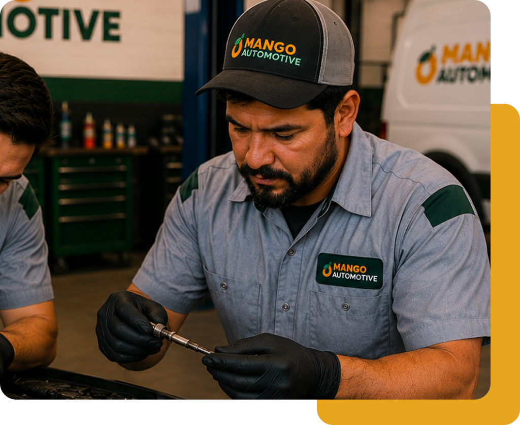 Mango Automotive technician in a branded cap working with a hand tool