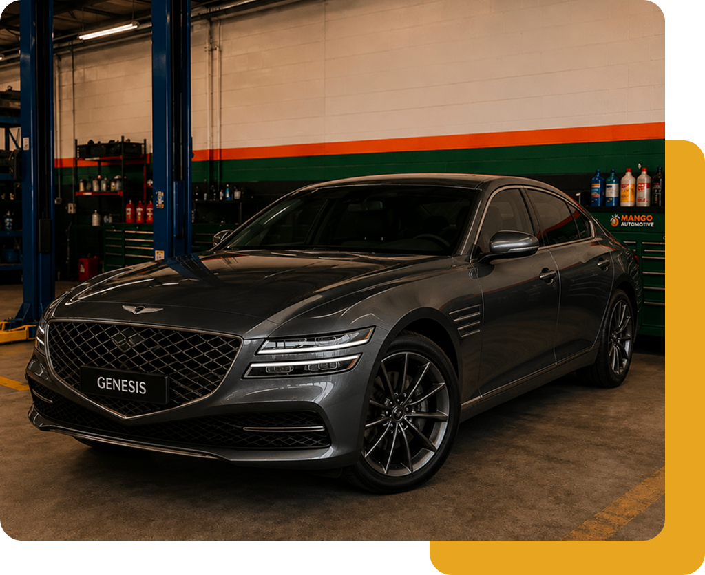 Dark gray Genesis sedan parked in a garage, front view with orange and green wall stripes behind it