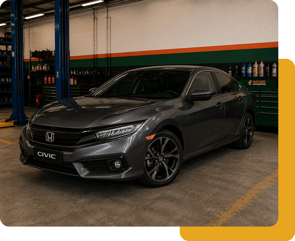Gray Honda Civic parked indoors in a garage, shown in a front three-quarter view.