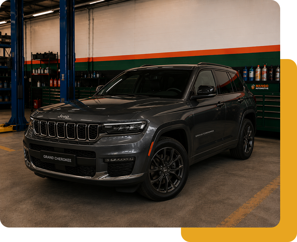Dark gray SUV parked in a garage, with black wheels and orange accents in the background.