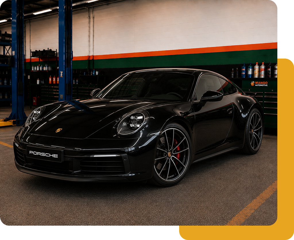 Black sports coupe parked in a garage with orange-and-green wall stripes