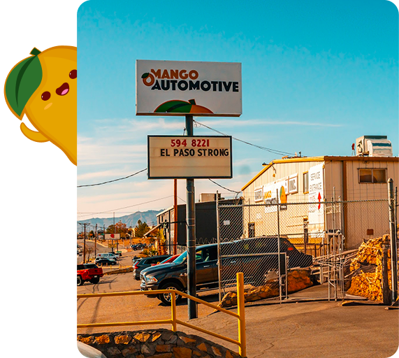 Mango Automotive sign above a fenced auto lot with parked cars under a clear blue sky