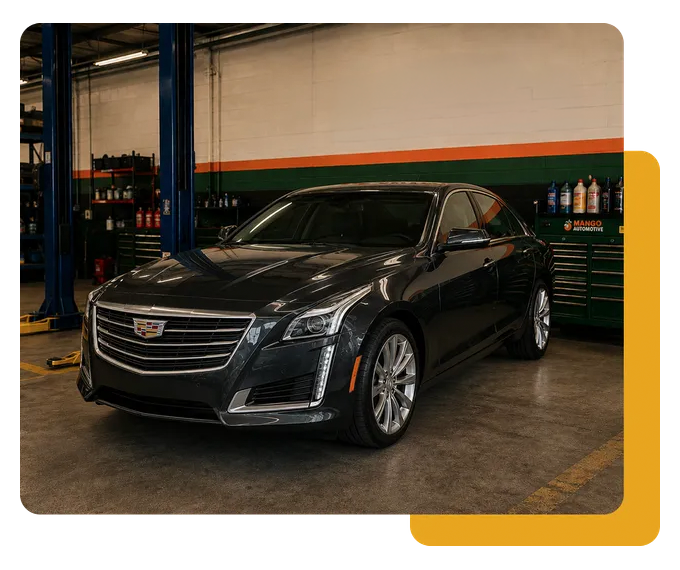 Black Cadillac sedan in an auto repair shop garage