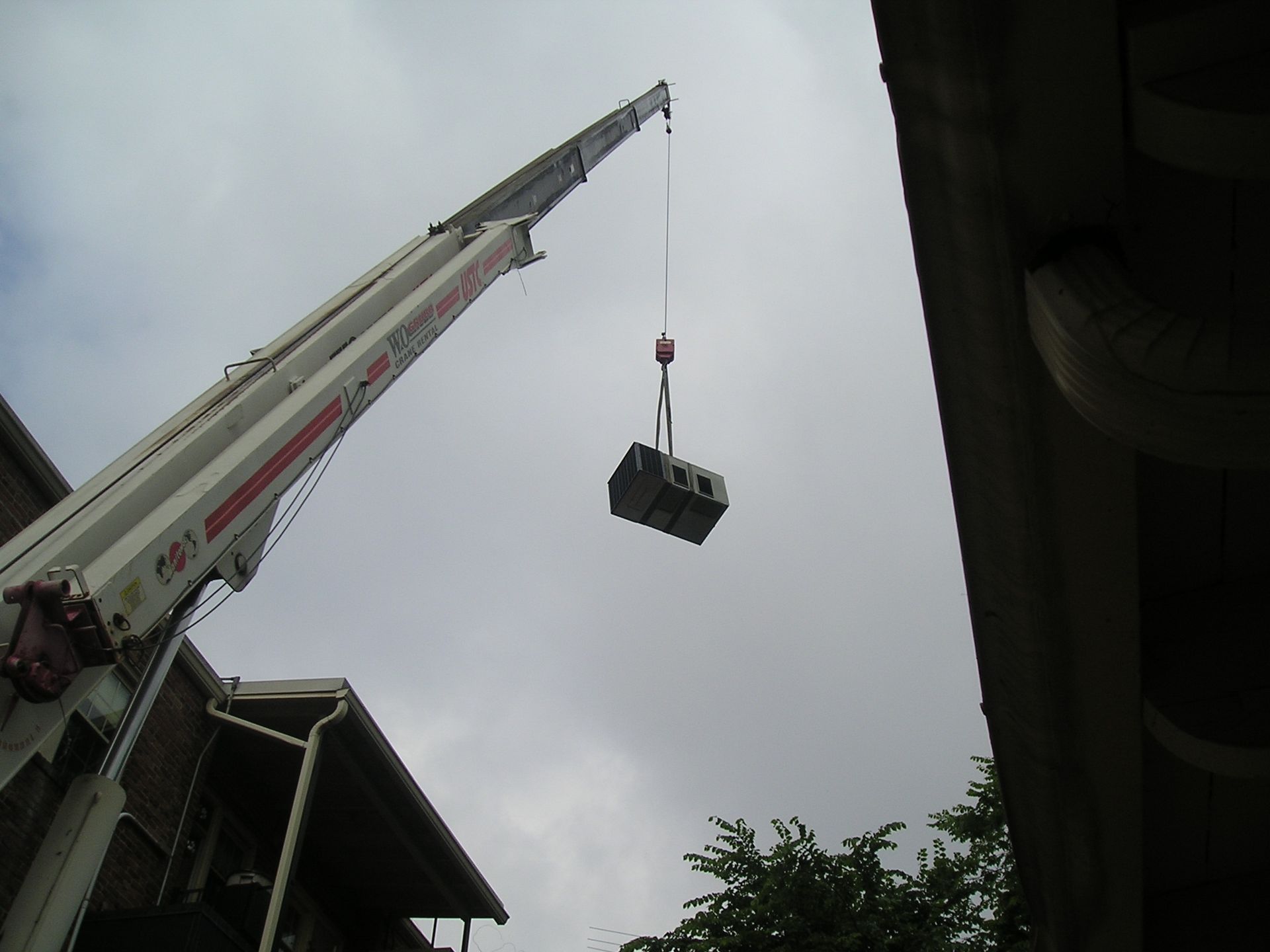 A Crane Lifting Up An HVAC Unit — Emporia, VA — Sunrise Heating & Air Conditioning