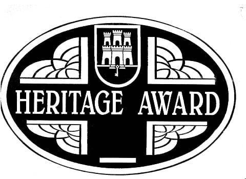 Black-and-white Heritage Award emblem with a central crest and decorative border
