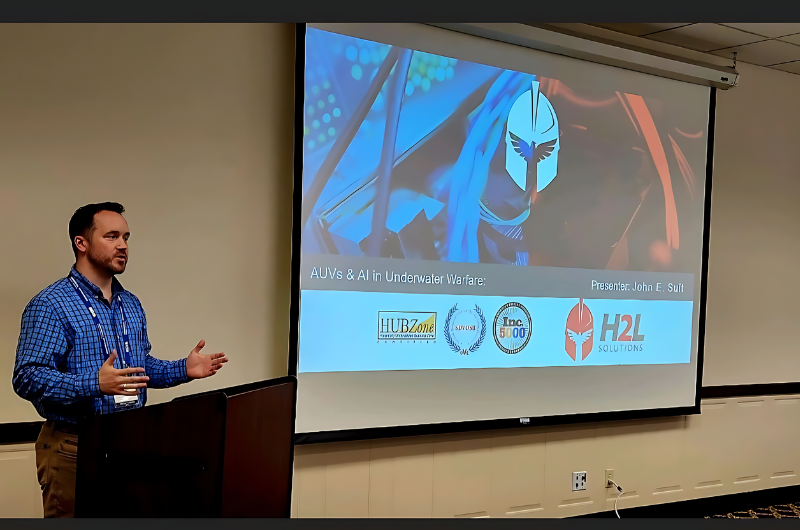A man is giving a presentation in front of a large screen.