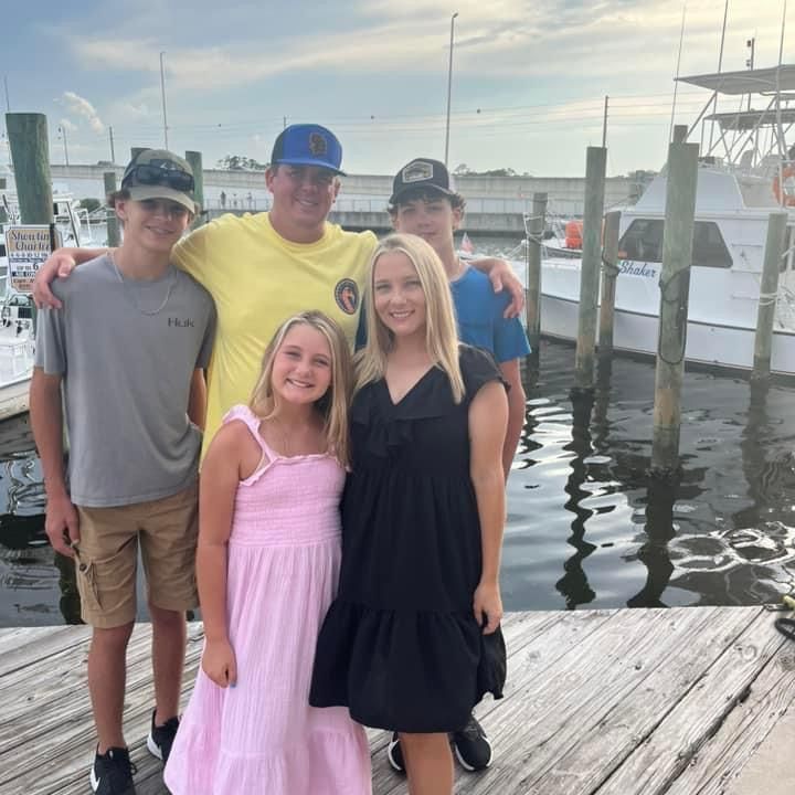 A group of people posing for a picture in front of a body of water