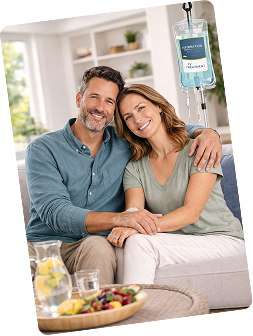 Smiling couple relaxing at home while receiving mobile IV therapy from NobleMed