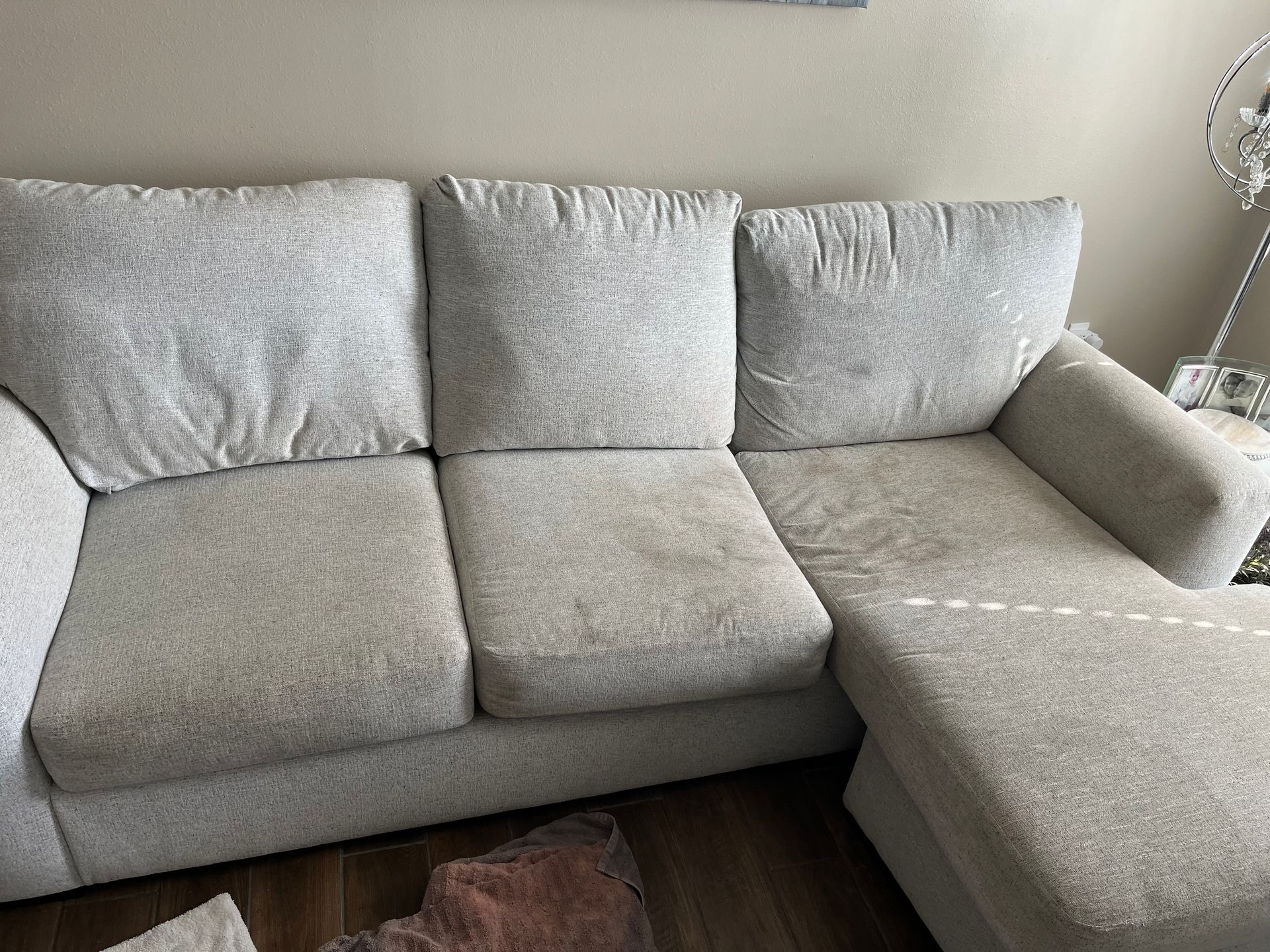 Light gray sofa with cushions in a living room, viewed from the front.