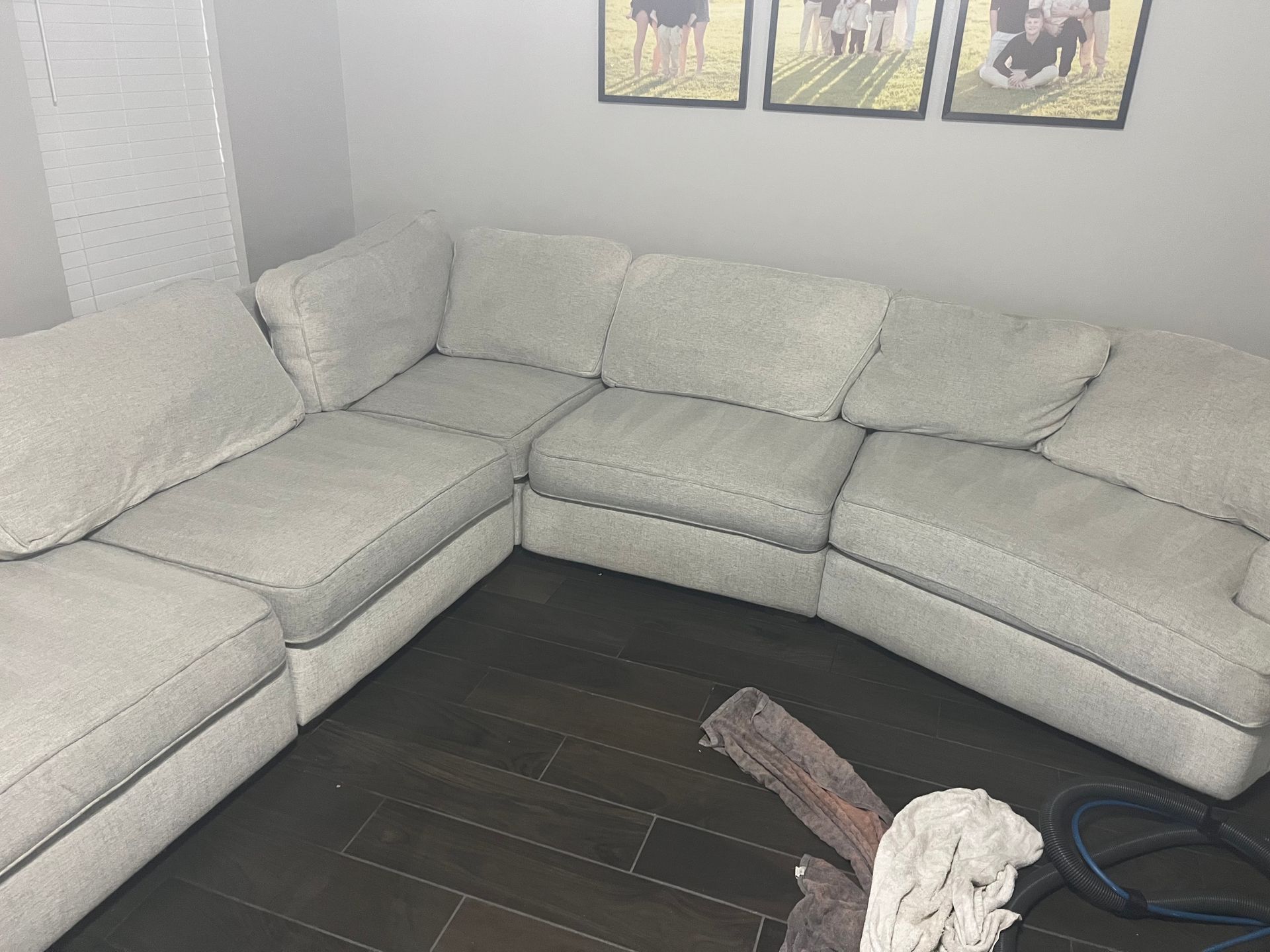 Light gray sectional sofa in a room with dark wood floor and framed wall art above