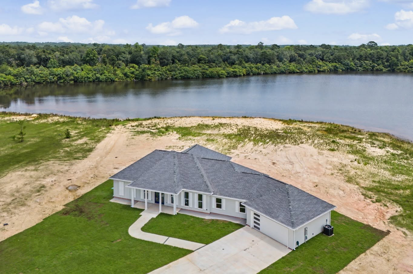Aerial view of a single-story custom home on a waterfront property