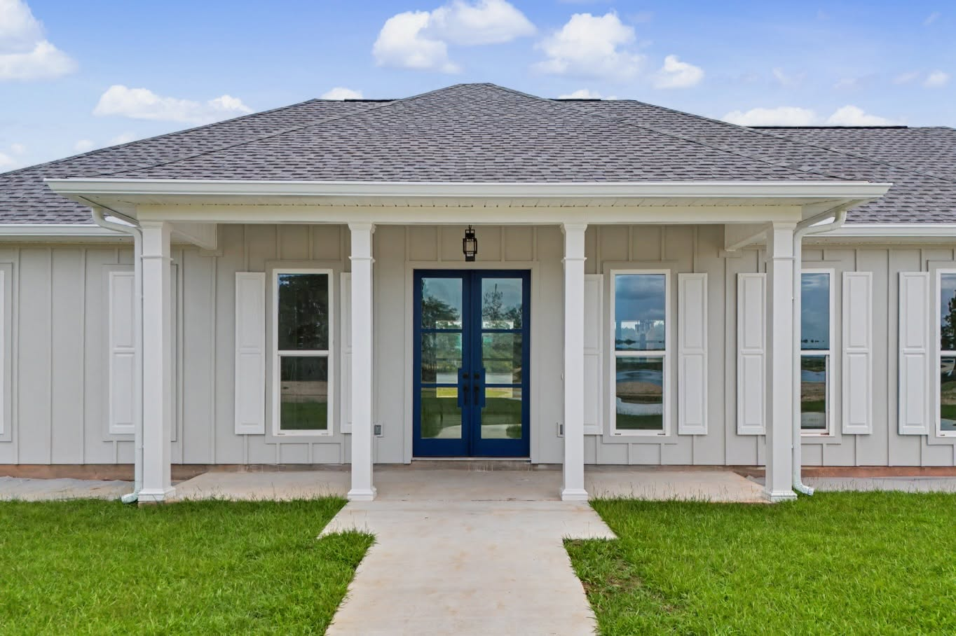Front exterior of a completed single-story custom home with a curved driveway and attached garage