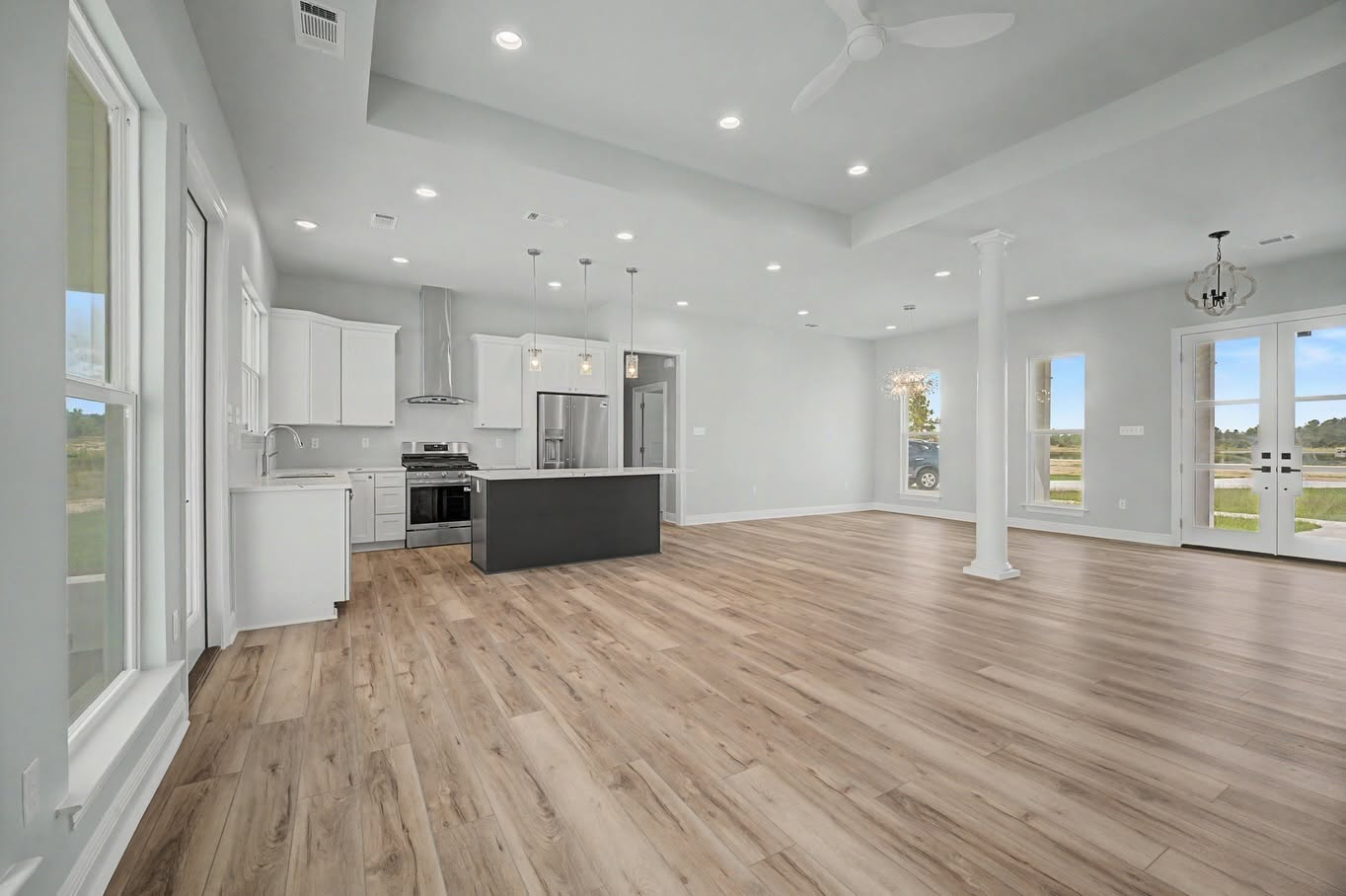 Open-concept custom home interior with a modern kitchen, dining area and wood-look flooring