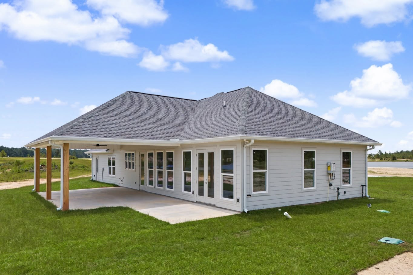 Rear exterior of a custom home with a covered patio and multiple glass doors