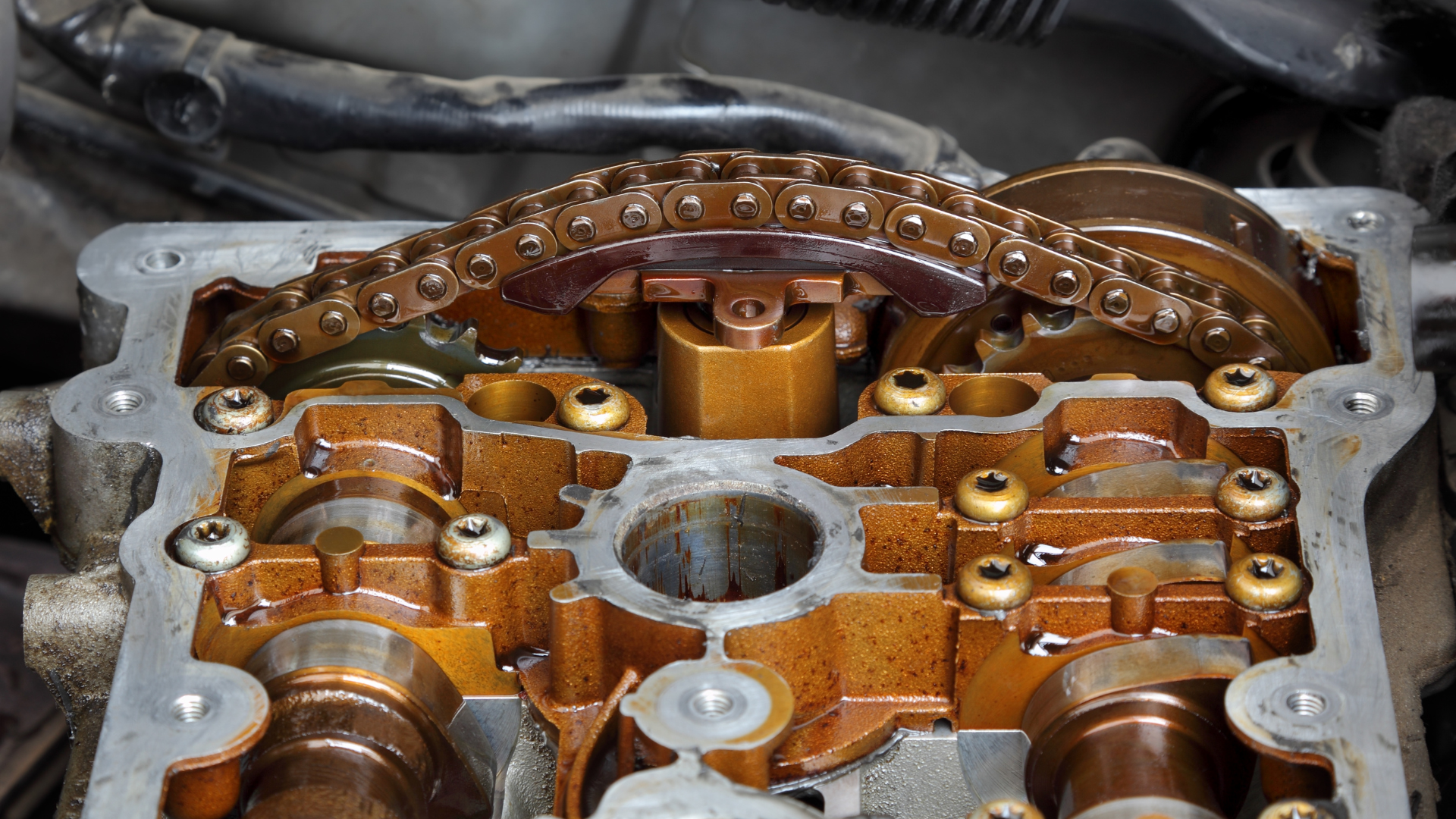 A close up of a car engine with a chain in it.