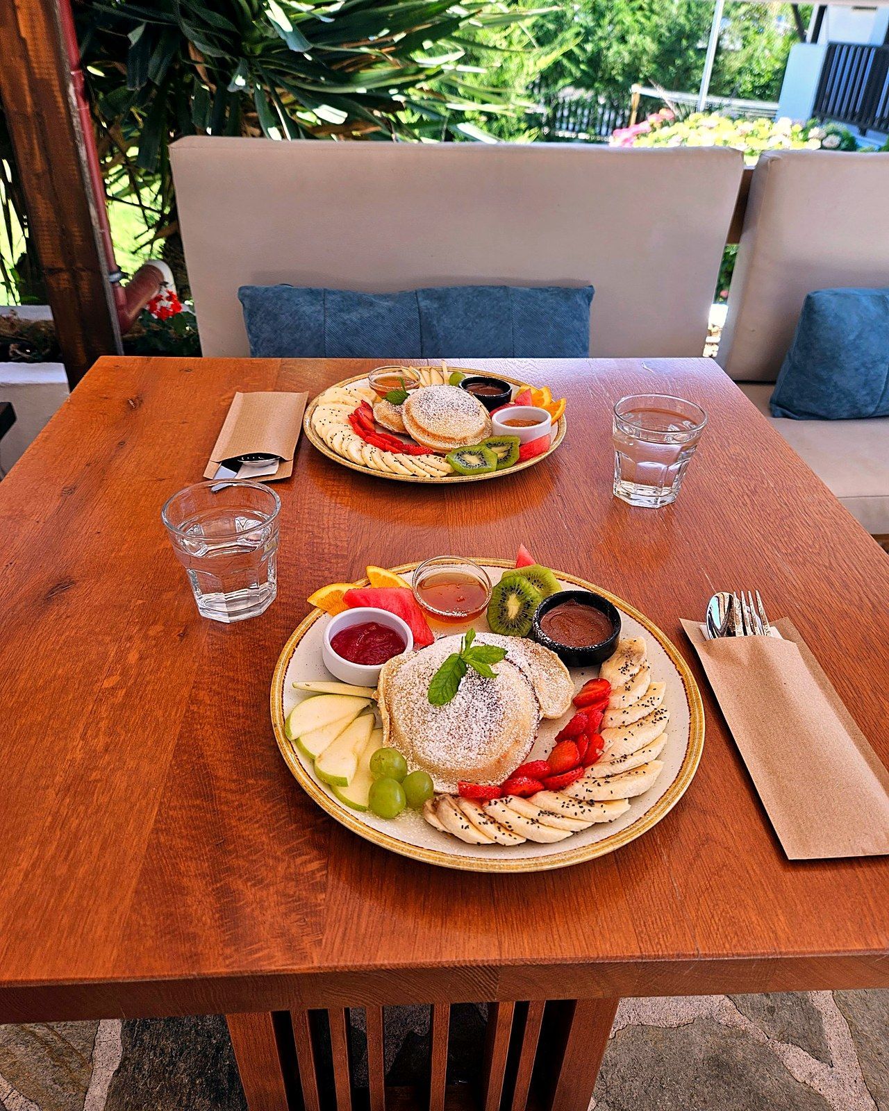 Pancakes with fresh fruit, honey and chocolate spread at the garden café of Villa Karina