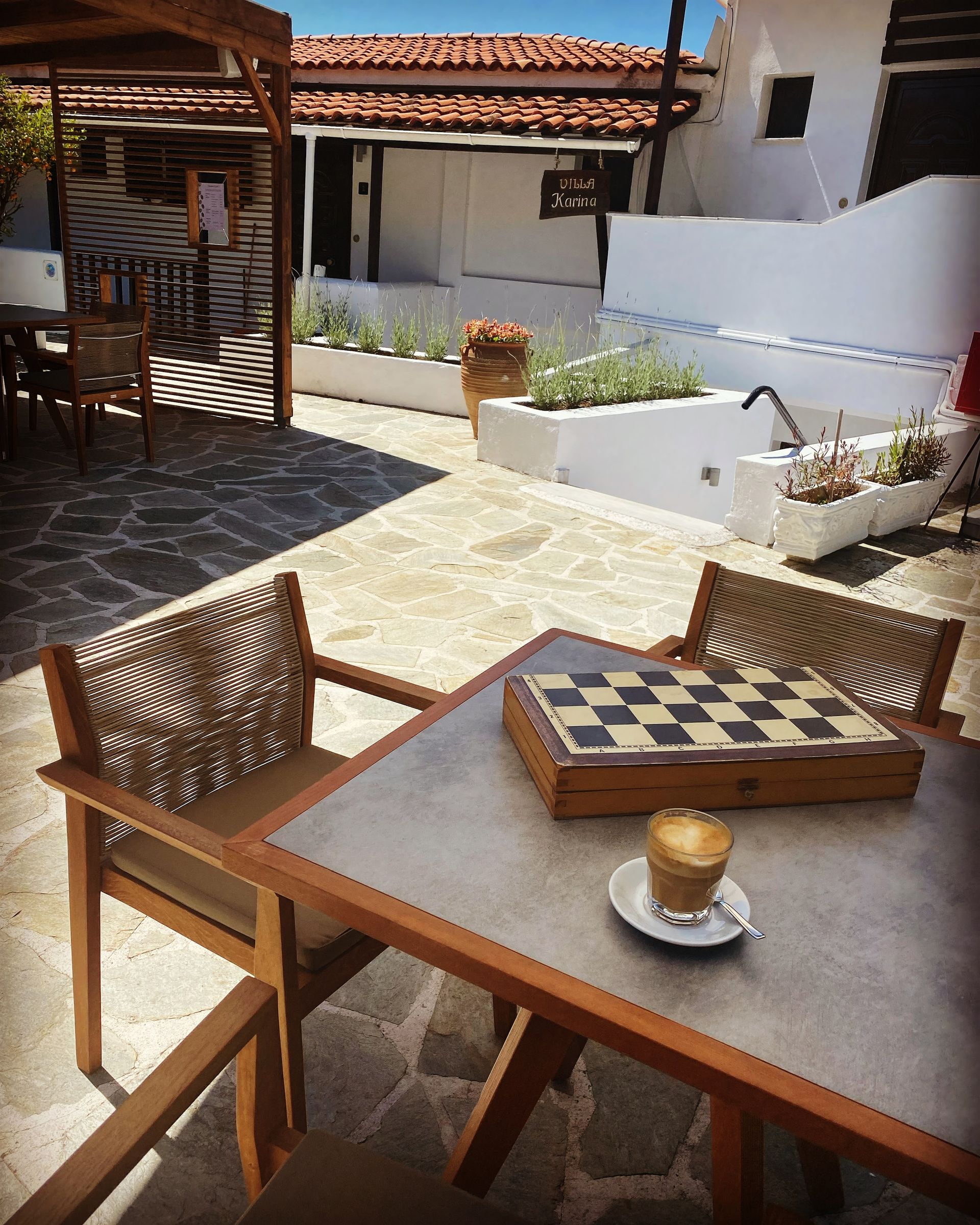 A table with a chess board and a cup of coffee on it