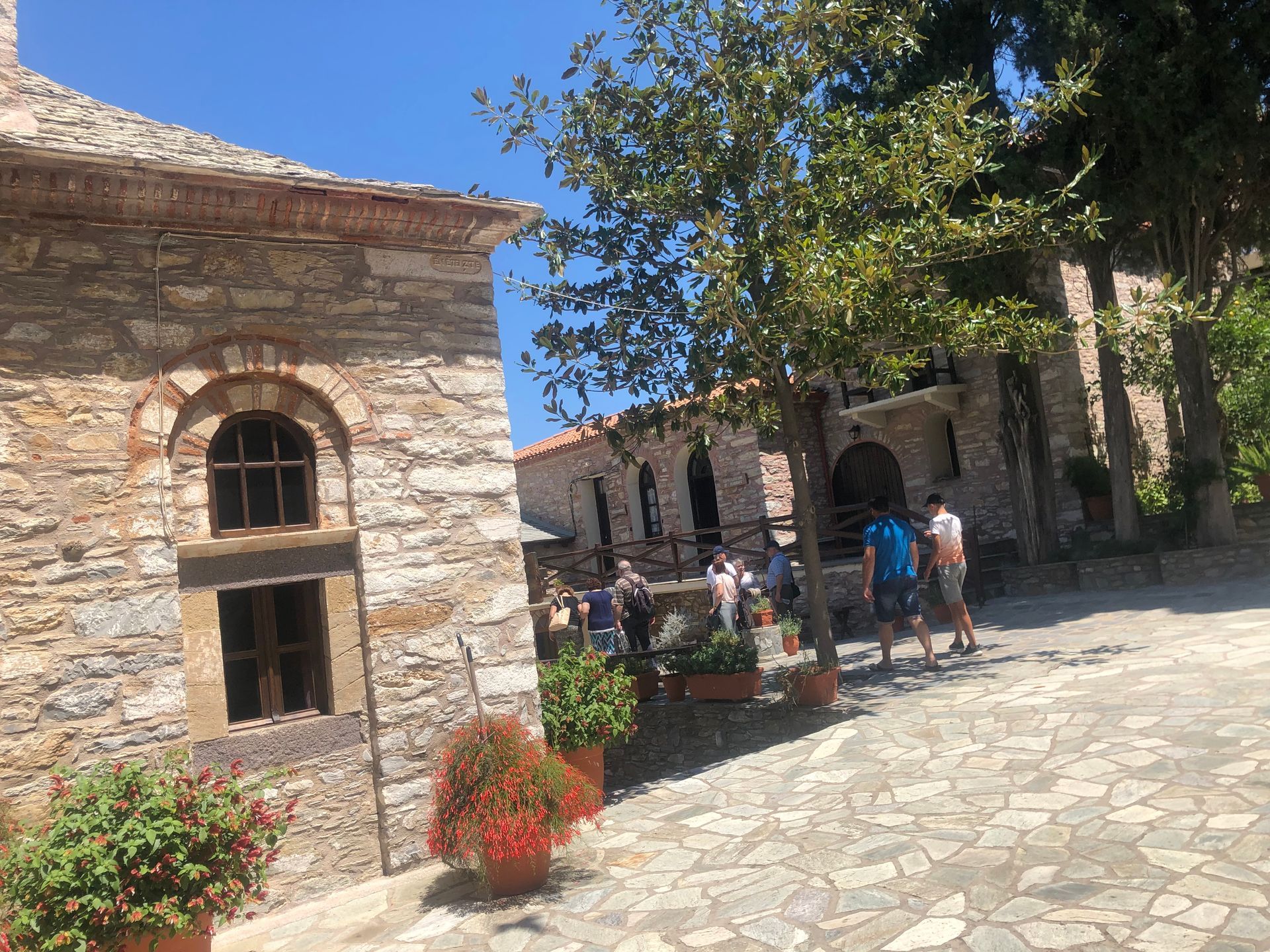 A group of people are standing in front of a stone building.
