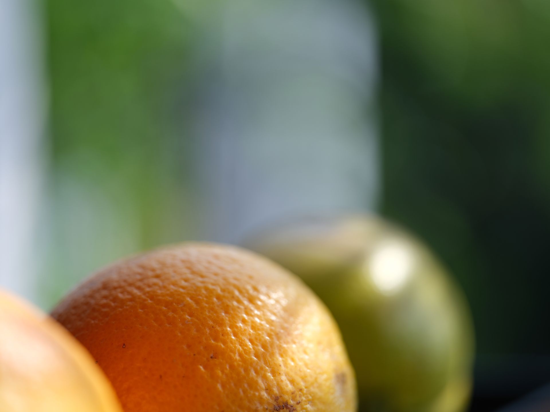 A bunch of oranges and limes are sitting on a table.
