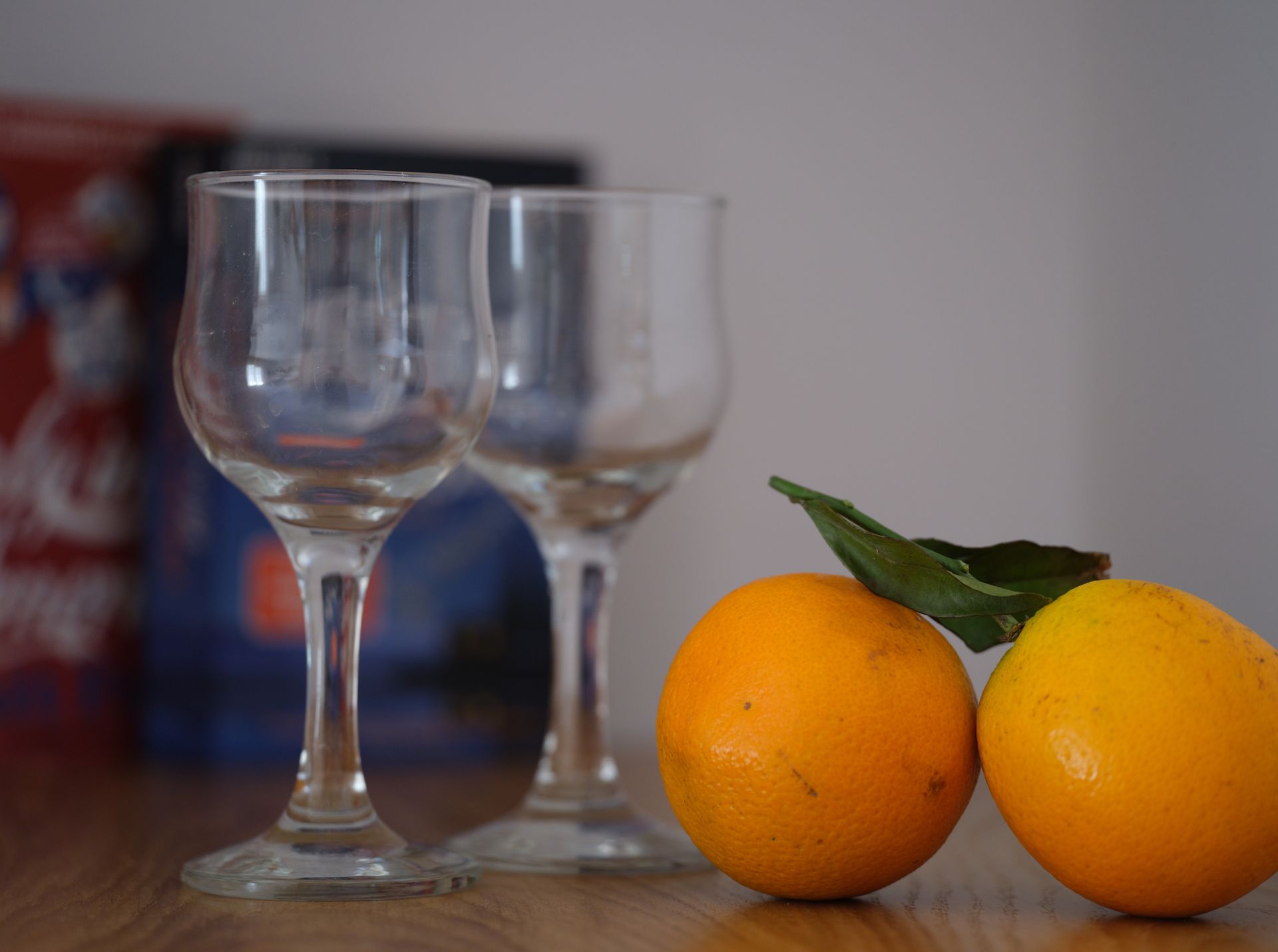 Two oranges and three wine glasses on a table