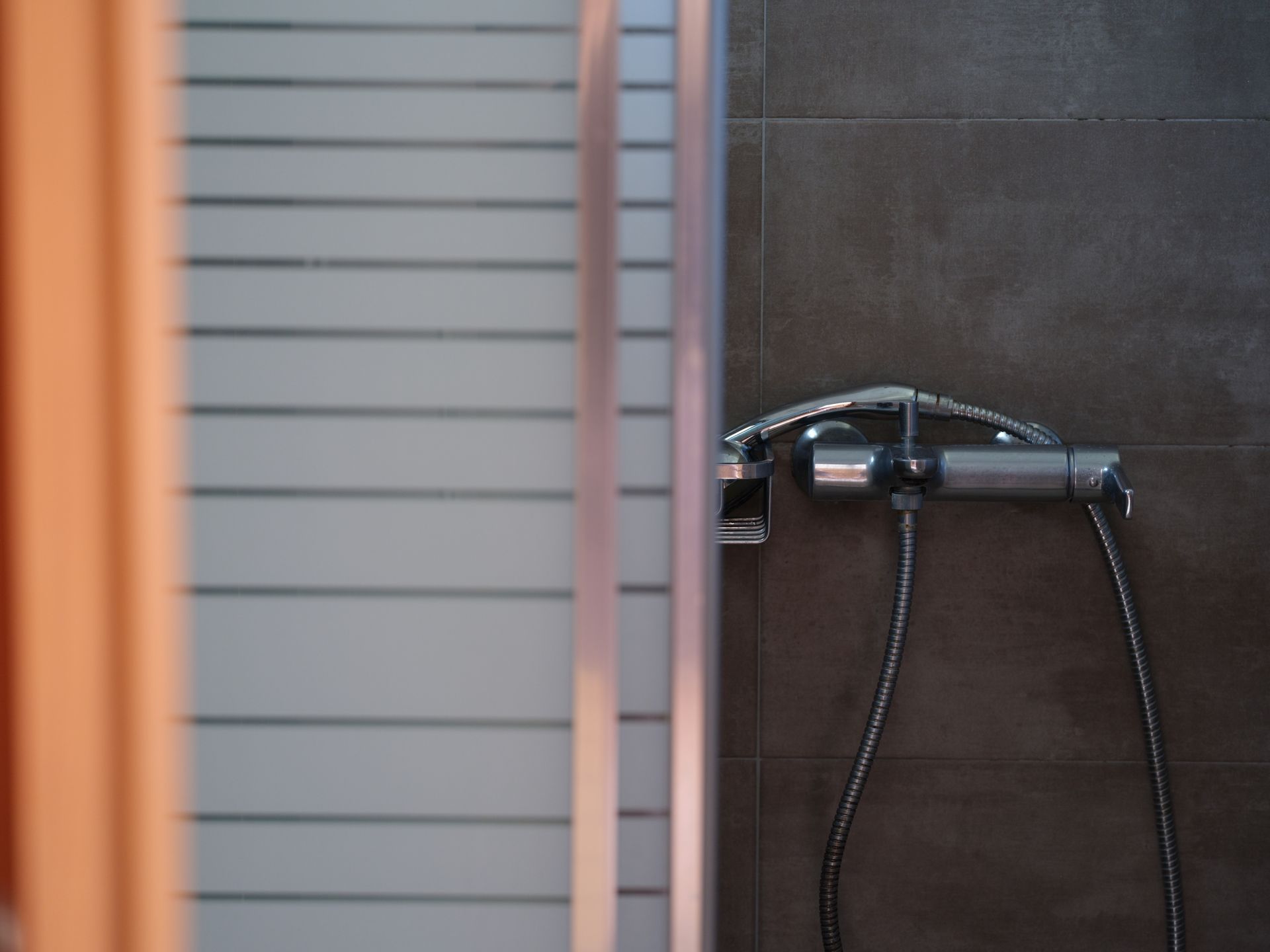 A close up of a shower head in a bathroom