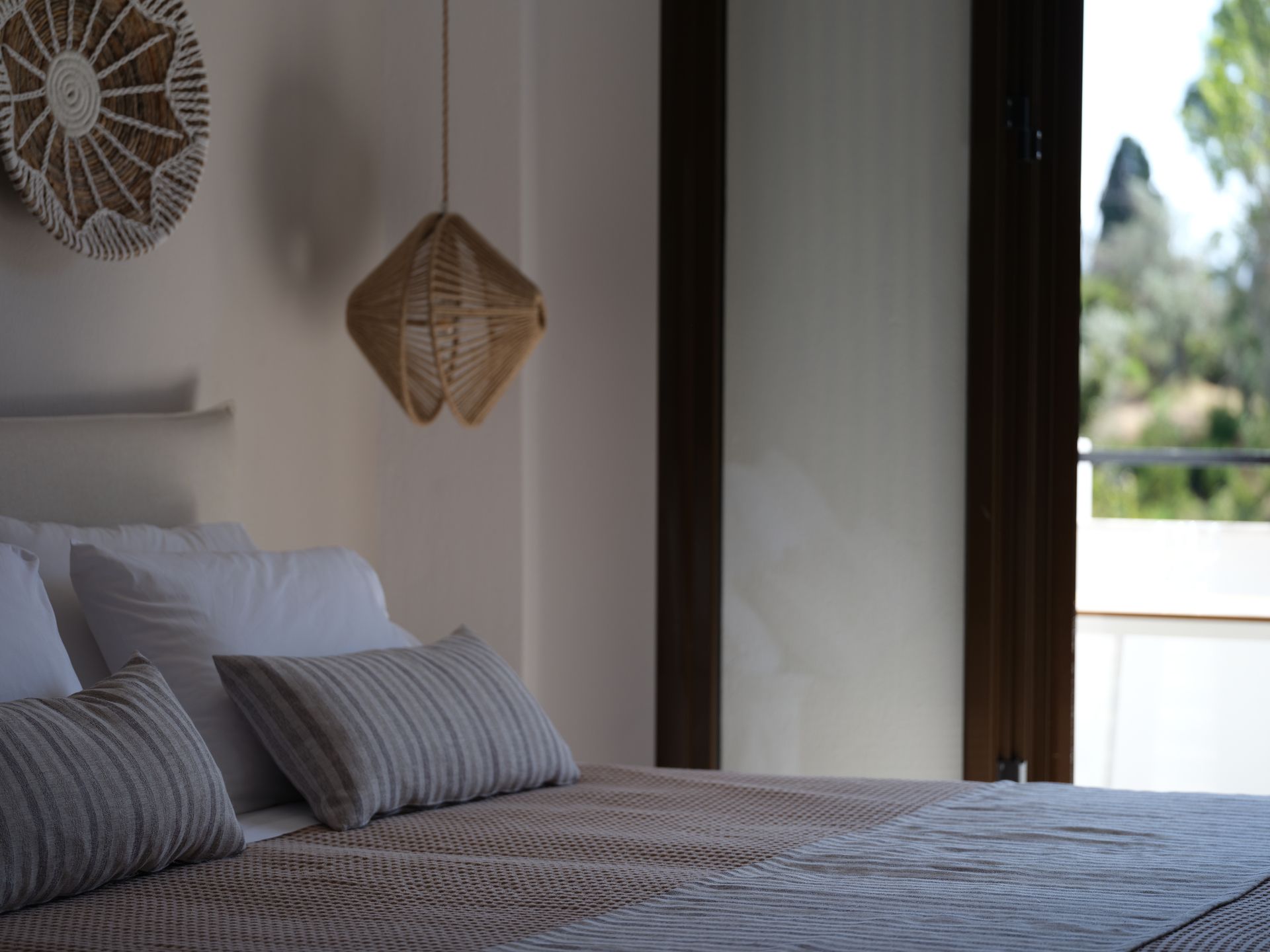 A bedroom with a bed , pillows , a lamp and a window.