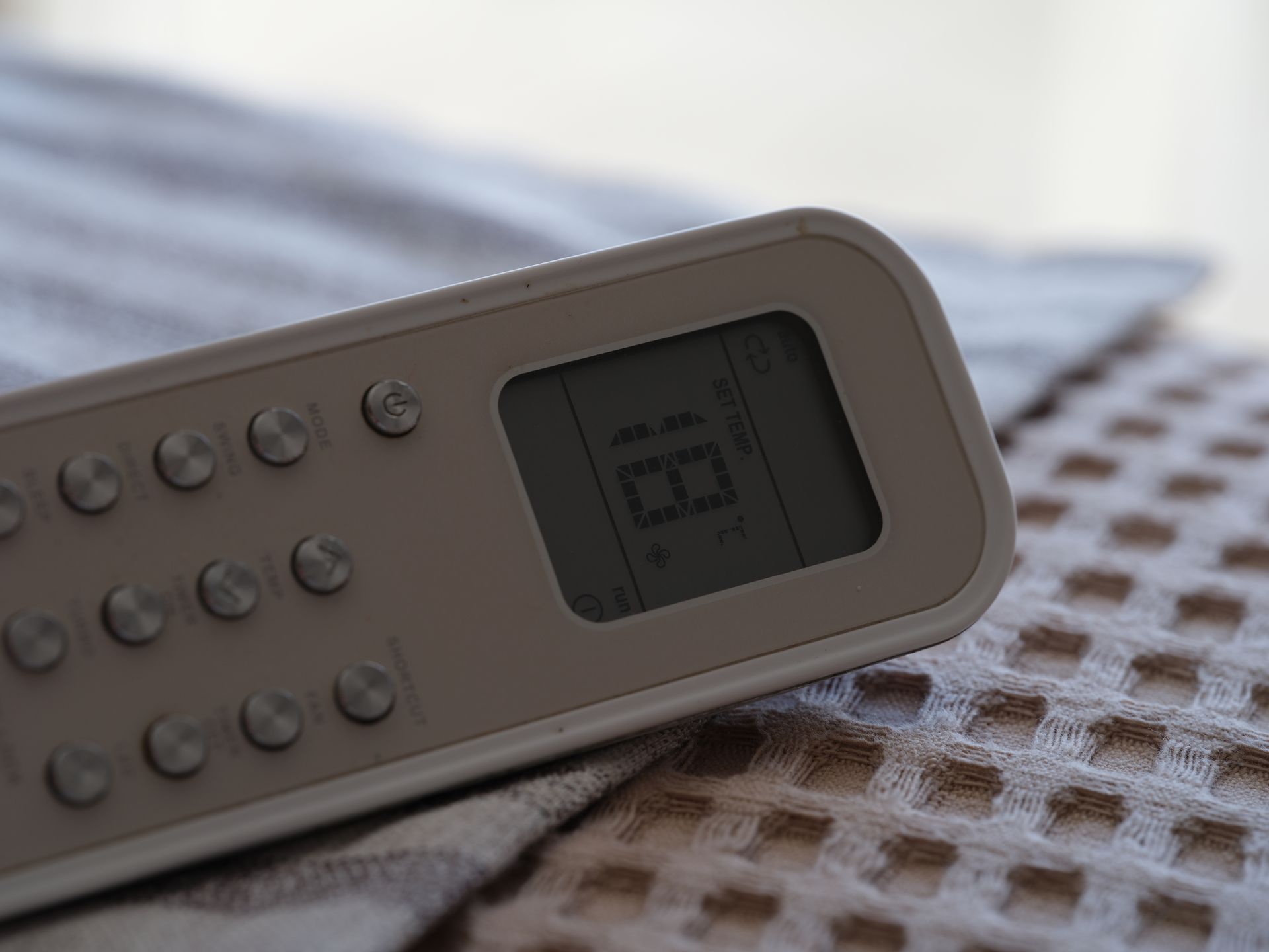 A remote control is sitting on a table with a digital display.