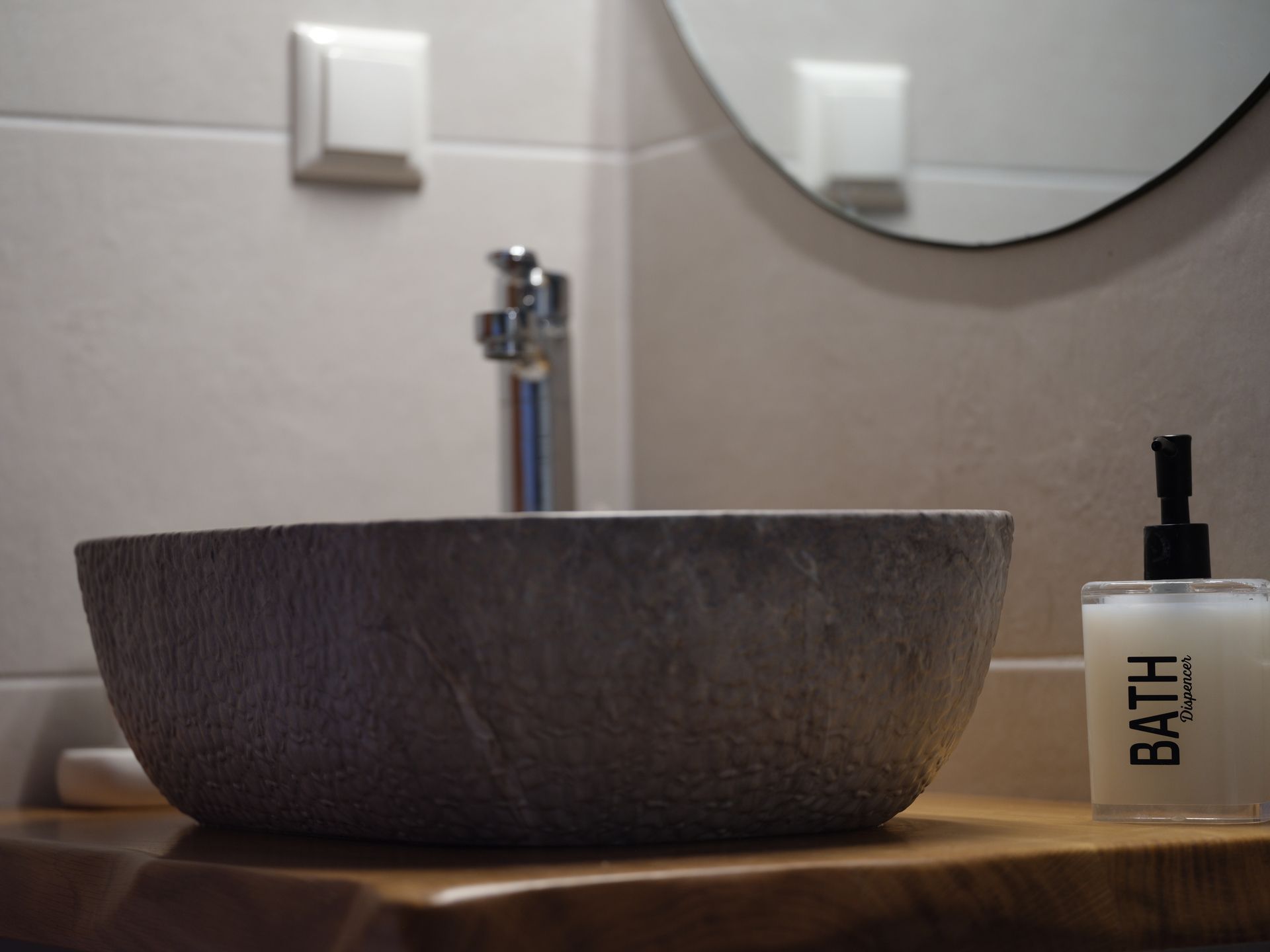 A bathroom with a sink and a bottle of bath soap