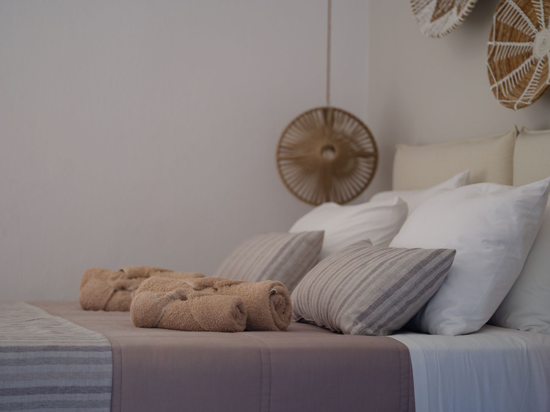 A bed with pillows and towels on it in a bedroom.