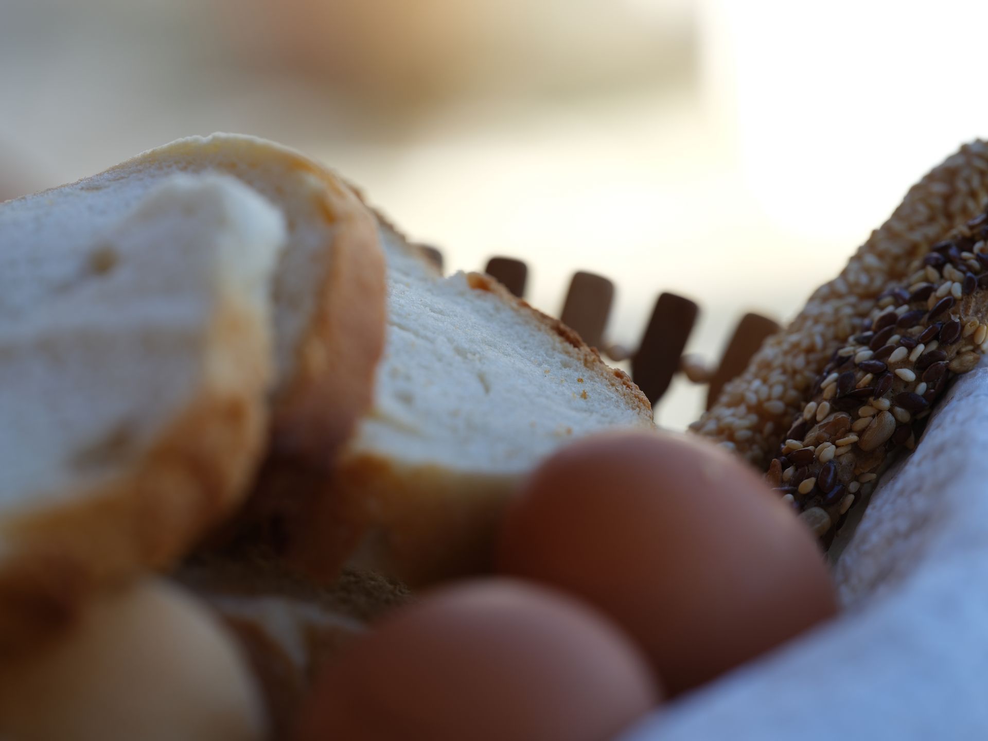 A person is holding a basket of bread in their hand.
