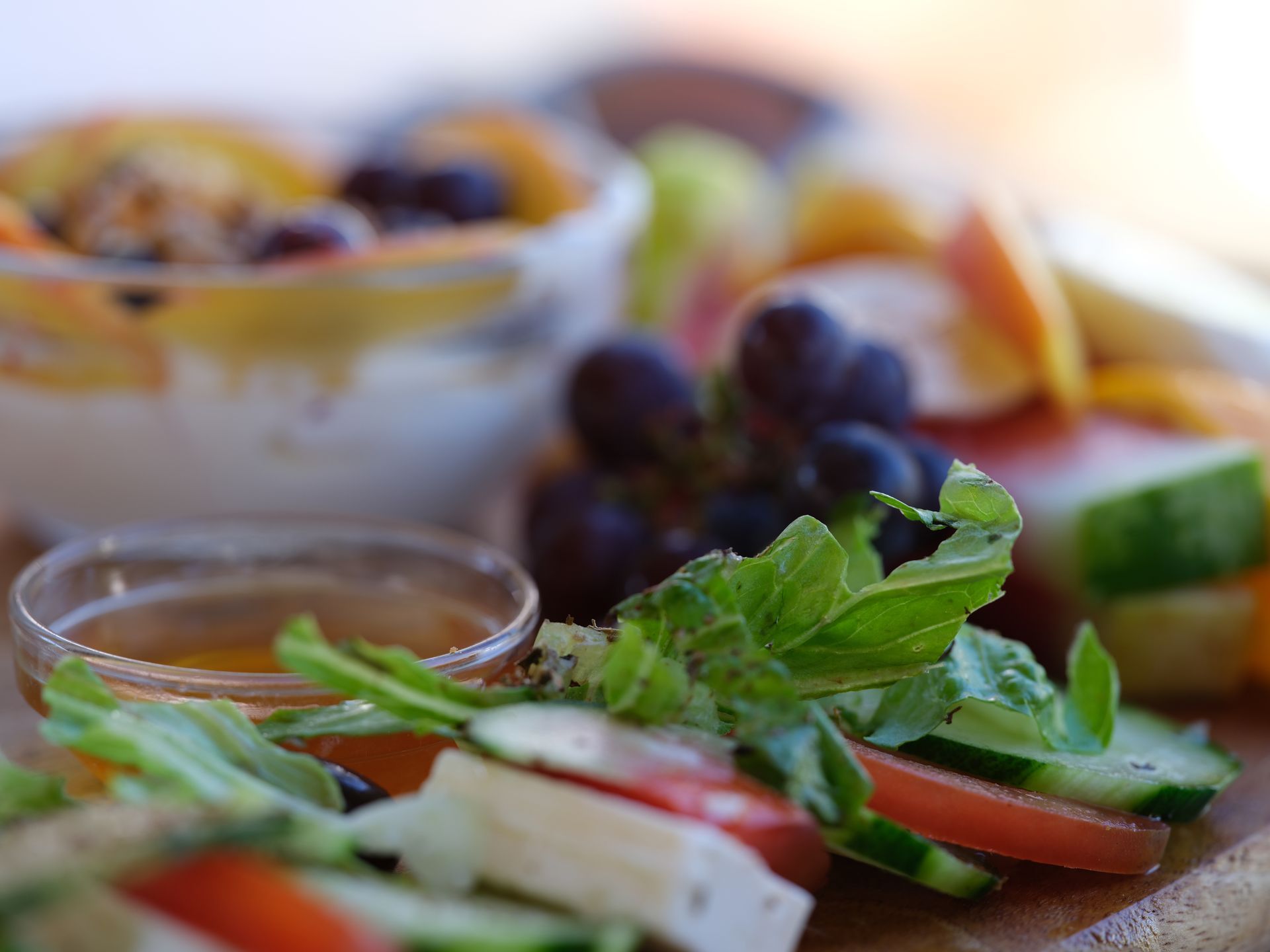 A close up of a plate of food with a bowl of fruit in the background.