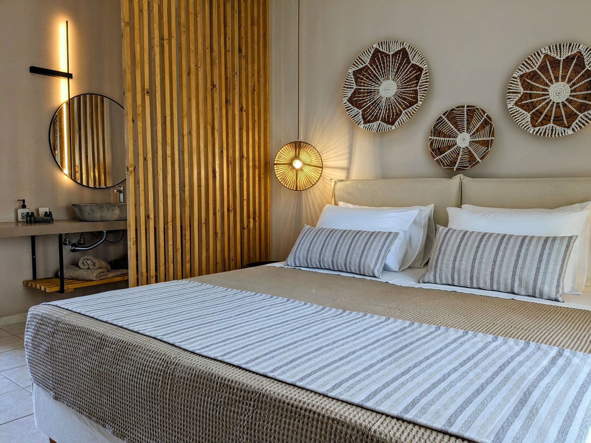 A bedroom with a large bed , a sink , and a mirror.
