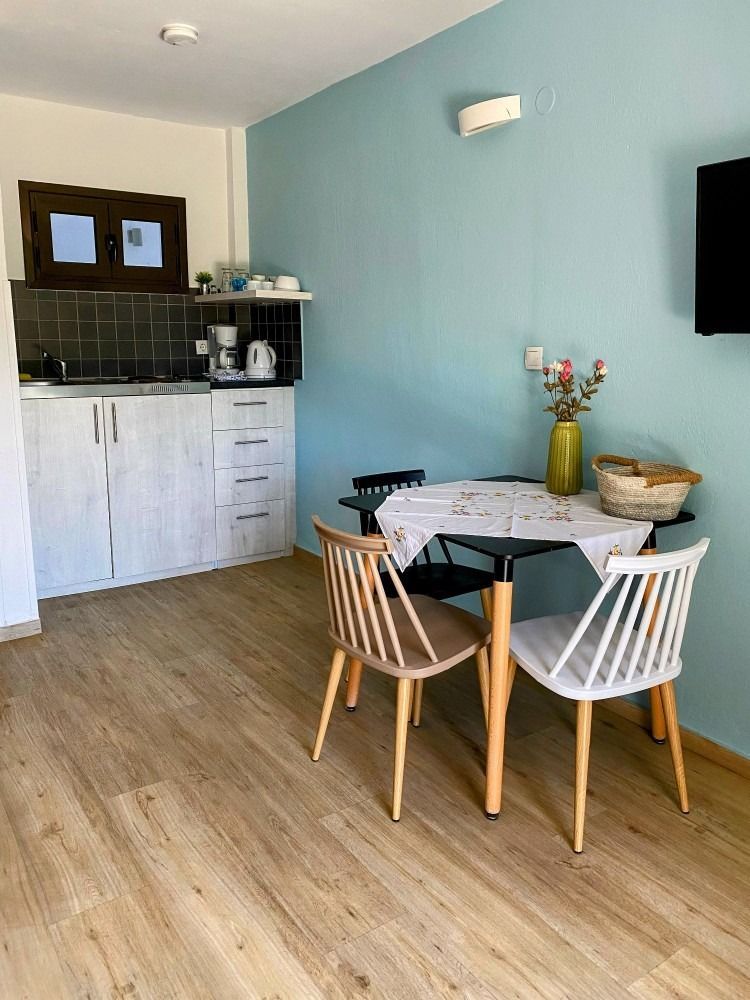 There is a table and chairs in the middle of the room.
