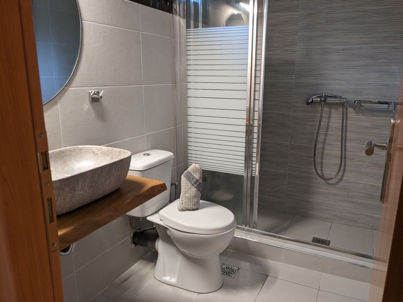 A bathroom with a toilet , sink and shower.