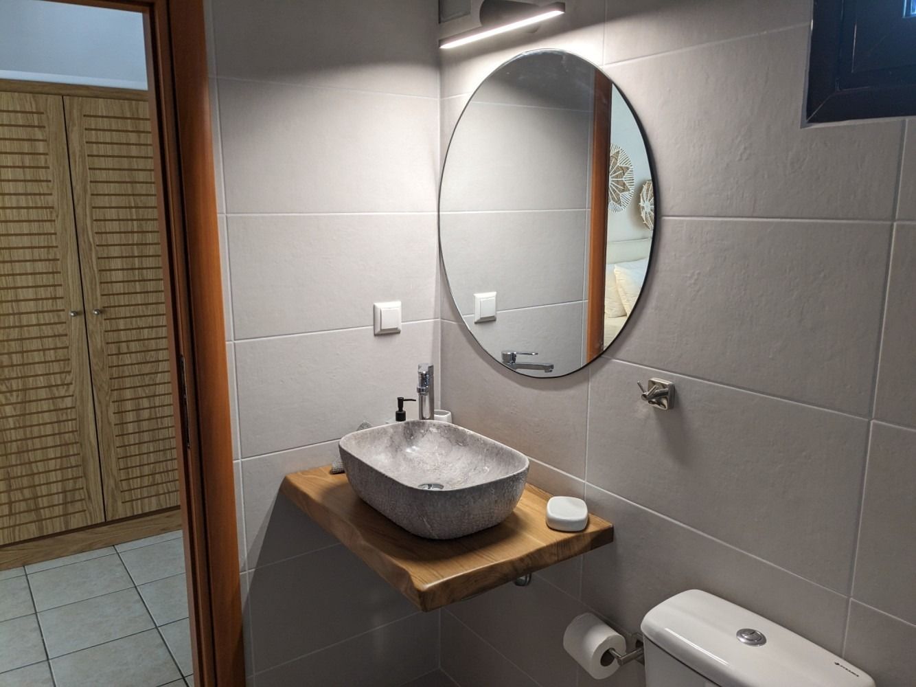 A bathroom with a sink , toilet and mirror.