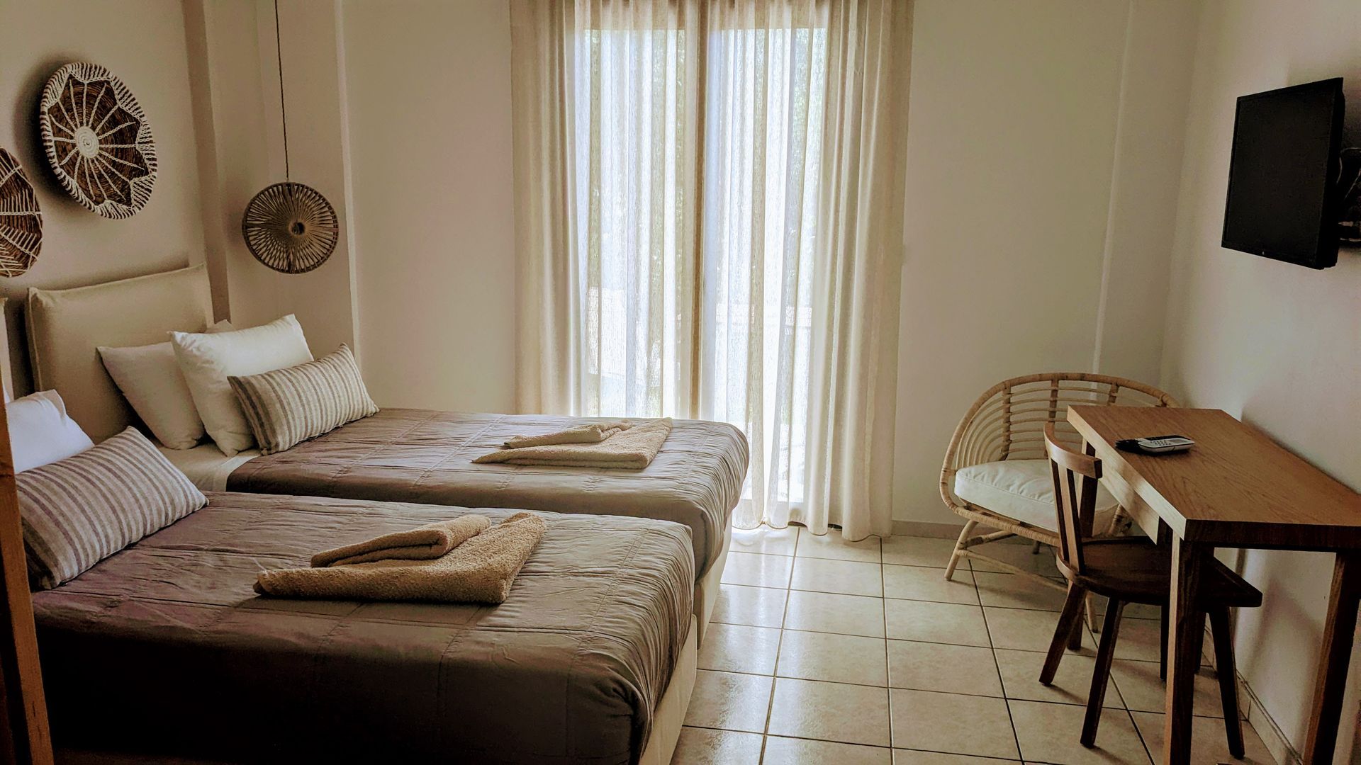 A hotel room with two beds , a desk and a television.