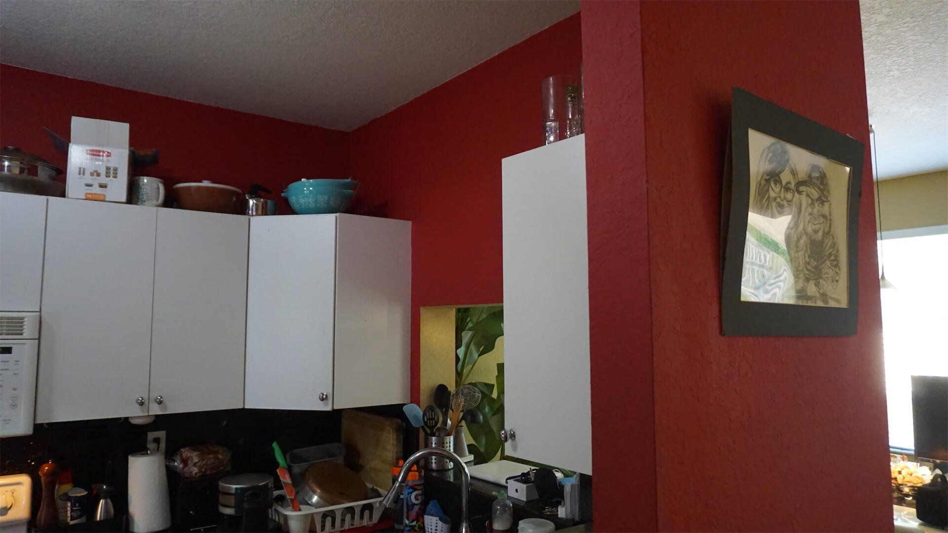 a kitchen with red walls and white cabinets