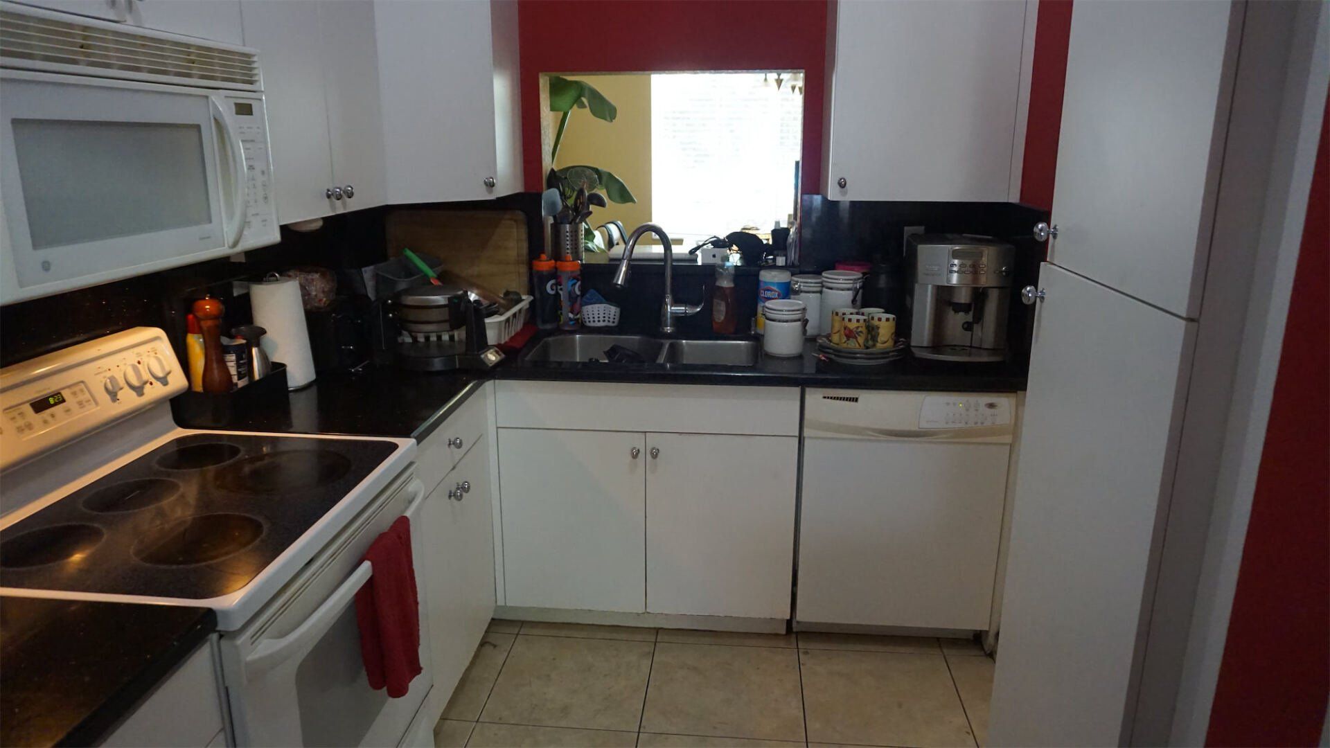 a kitchen with white cabinets and black counter tops